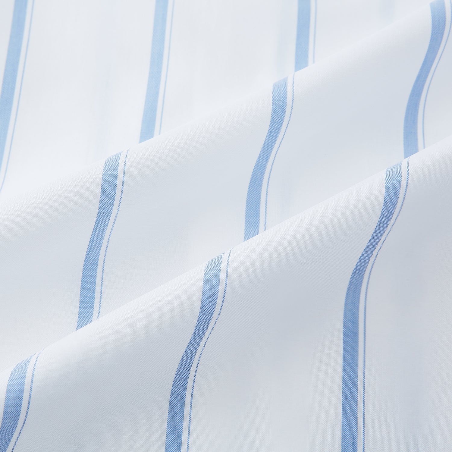 View 6 of product The Colony Blue Track Stripe Mayfair Shirt by Turnbull & Asser is a long-sleeve, button-up Italian cotton shirt with a white base and blue stripes, pointed collar, and buttoned cuffs, shown laid flat on a white background.