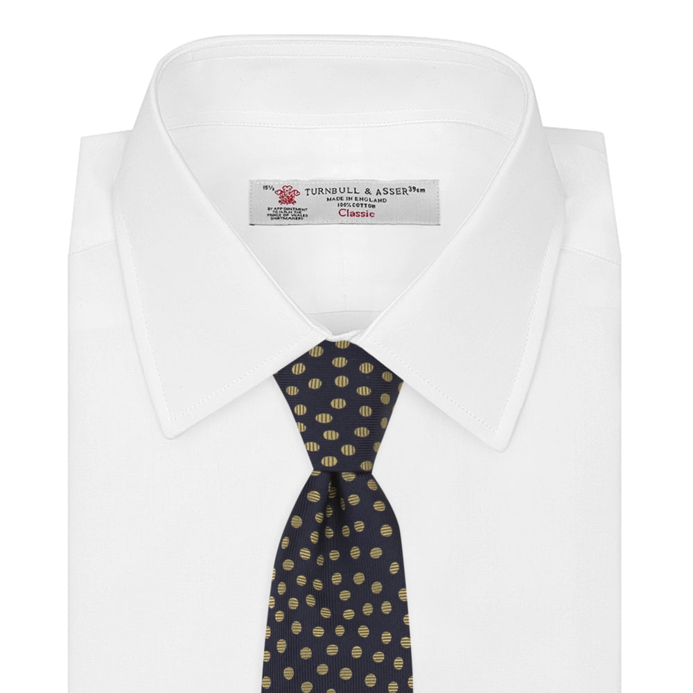 The Turnbull & Asser Navy and Gold Paint Spot Silk Tie features evenly spaced gold spots on classic navy silk, rolled and displayed on a plain white background—ideal for complementing your favorite office shirt.