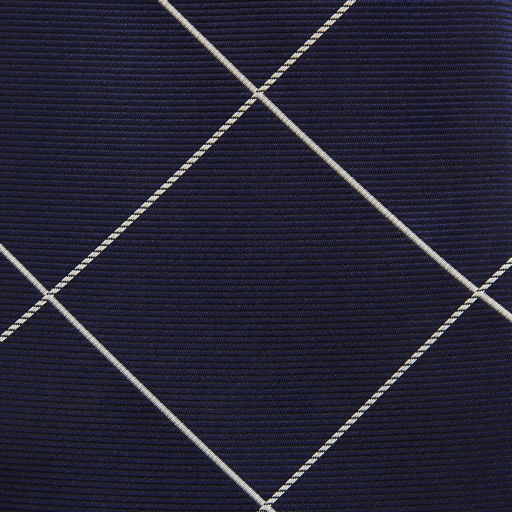 The Turnbull & Asser WINDOW PANE NAVY WHITE TIE features navy blue silk with a subtle diagonal ribbed texture and white windowpane checks, making it the perfect men’s accessory for any formal occasion.