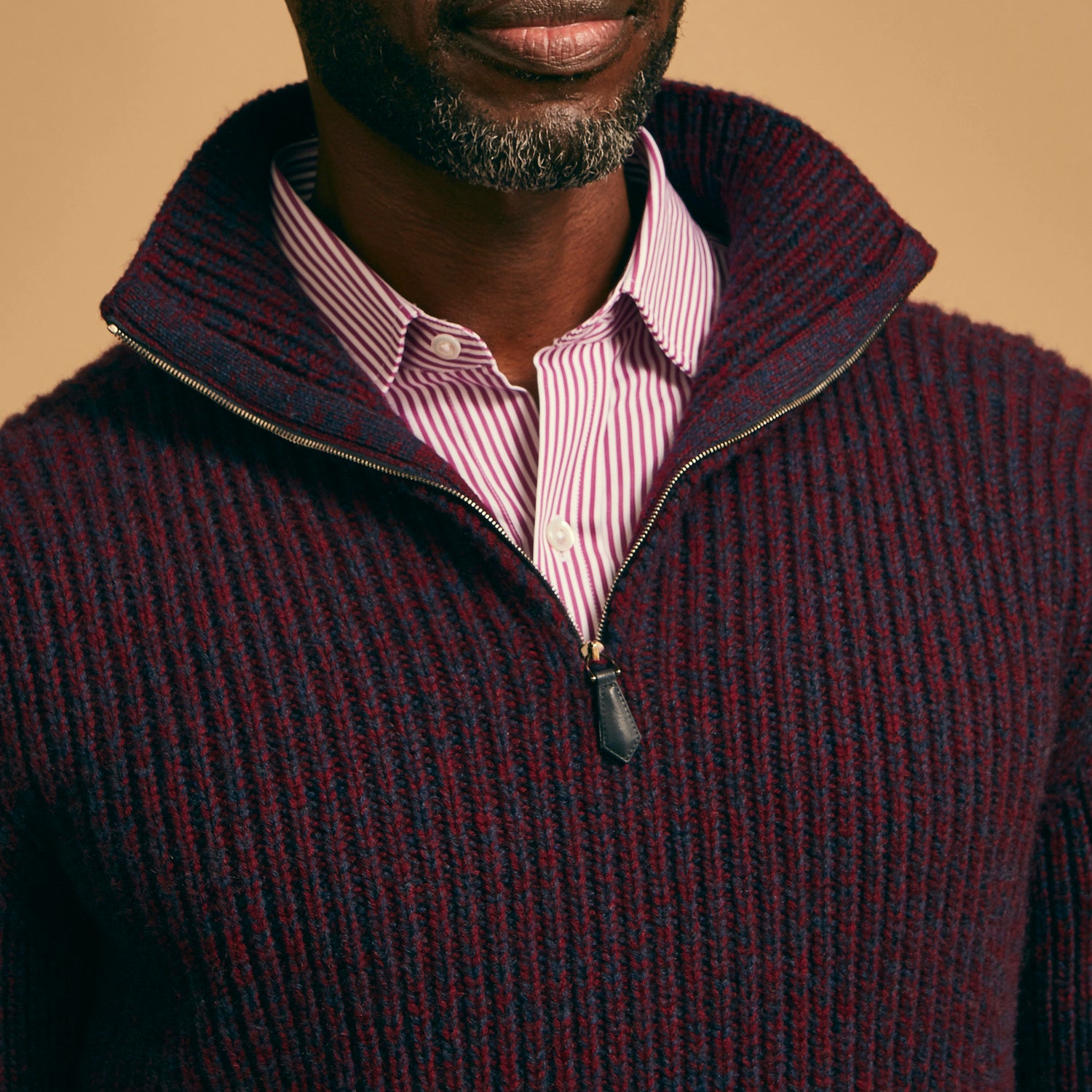 View 4 of product The Turnbull & Asser Burgundy Mullion Half Zip Rib Cashmere Jumper features a high collar and half-zip front in dark red and navy cashmere, shown laid flat on a white background—ideal for an elevated casual look.
