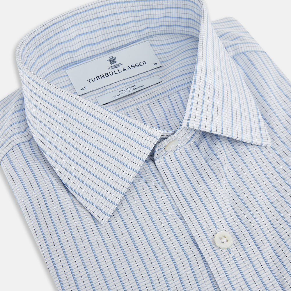 The Turnbull & Asser Blue Graph Check Mayfair Shirt features a classic T&A collar, Mayfair fit, buttoned cuffs, and long sleeves with light blue graph checks on a white background.