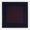 View 4 of product The Turnbull & Asser Navy and Red Dot Silk Pocket Square features a dark navy blue base with small red polka dots on the border and inner pattern, all handmade and neatly folded.