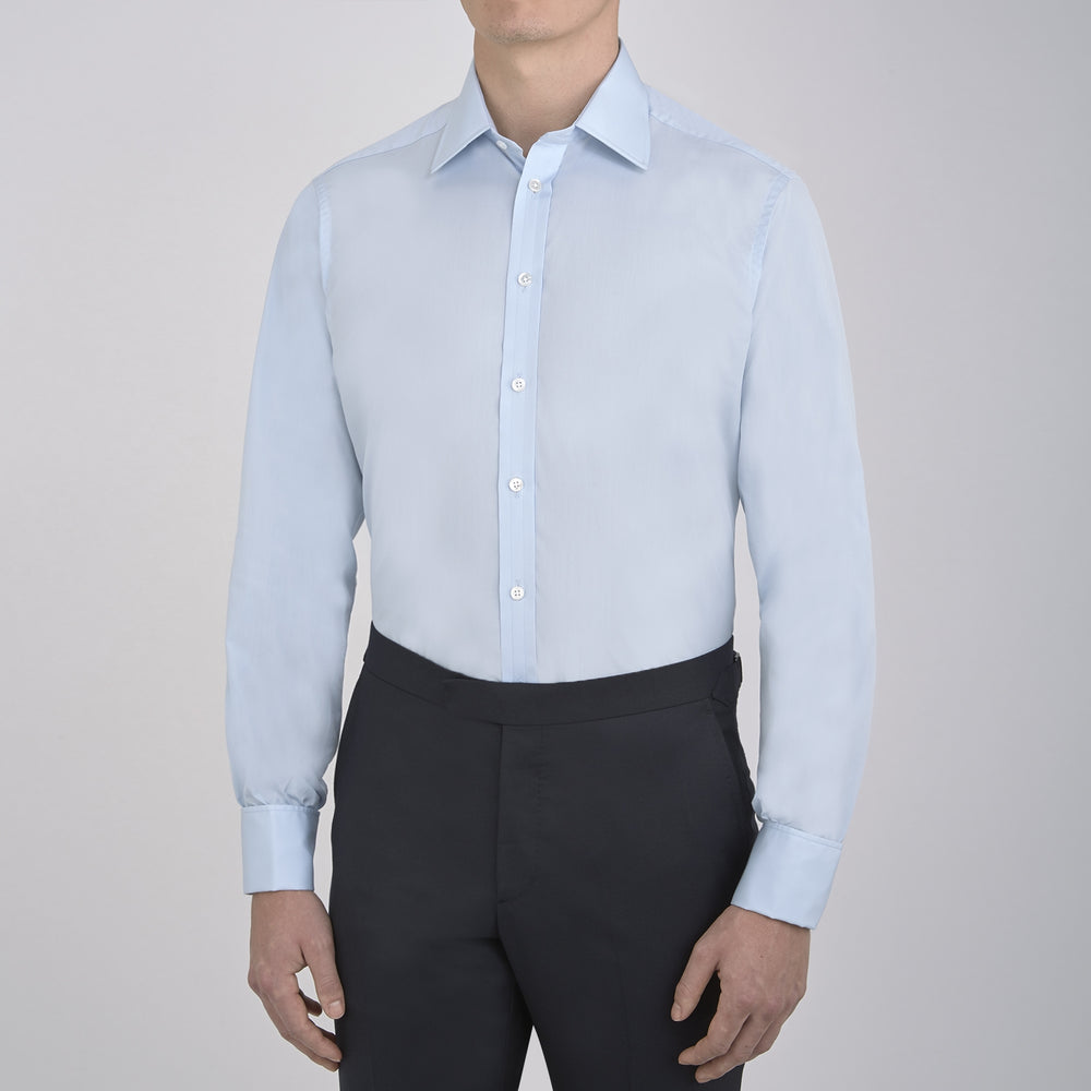 The Turnbull & Asser Light Blue Sea Island Quality Cotton Shirt features a T&A collar, double cuffs, white buttons, and a quality label inside the collar. Displayed on a plain white background.