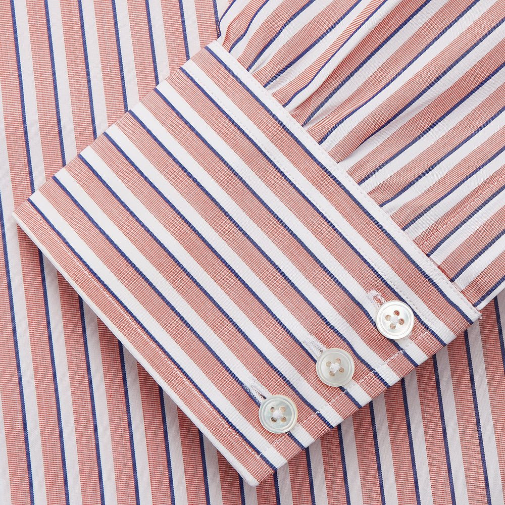 The Turnbull & Asser Orange and White Stripe Cotton Regular Fit Mayfair Shirt features vertical stripes, a classic collar, and buttoned cuffs—an essential men’s wardrobe piece, shown laid flat on a white background.