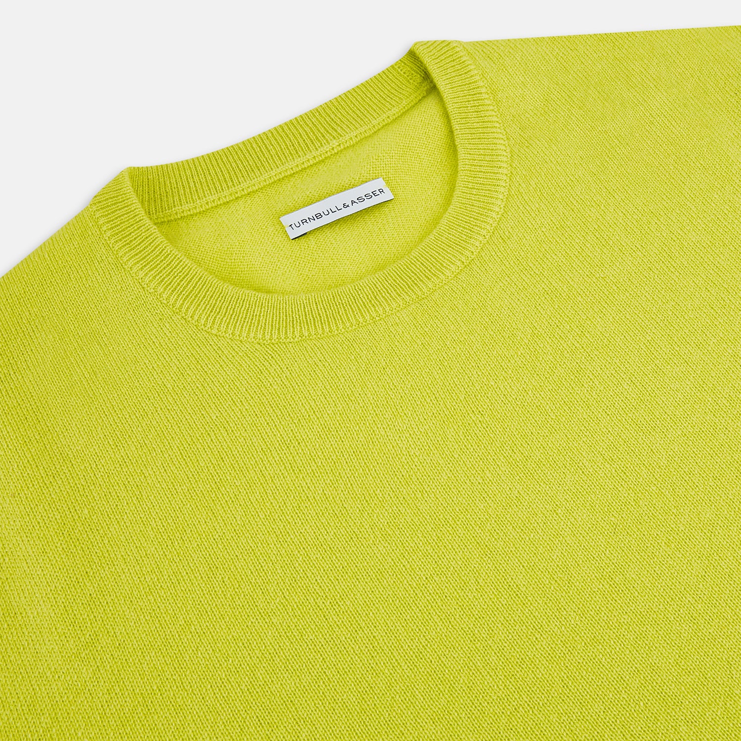 View 9 of product The Turnbull & Asser Lemon Green Cashmere Round Neck Jumper features long sleeves with ribbed cuffs and hem, displayed on a white background.