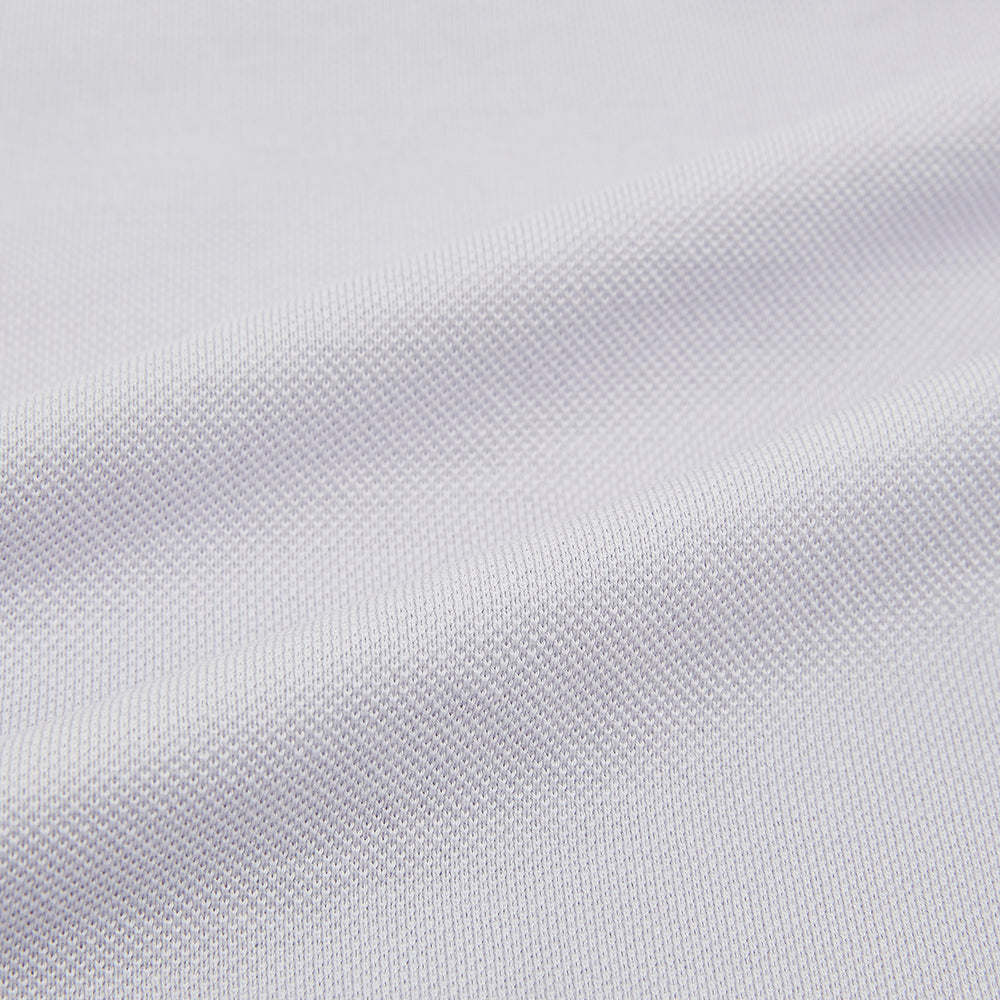 A soft pink cotton polo shirt by Turnbull & Asser features short sleeves, a contrasting white collar, three dark buttons, and a left chest pocket. Laid flat on a white background—it’s perfect for modern men’s fashion.