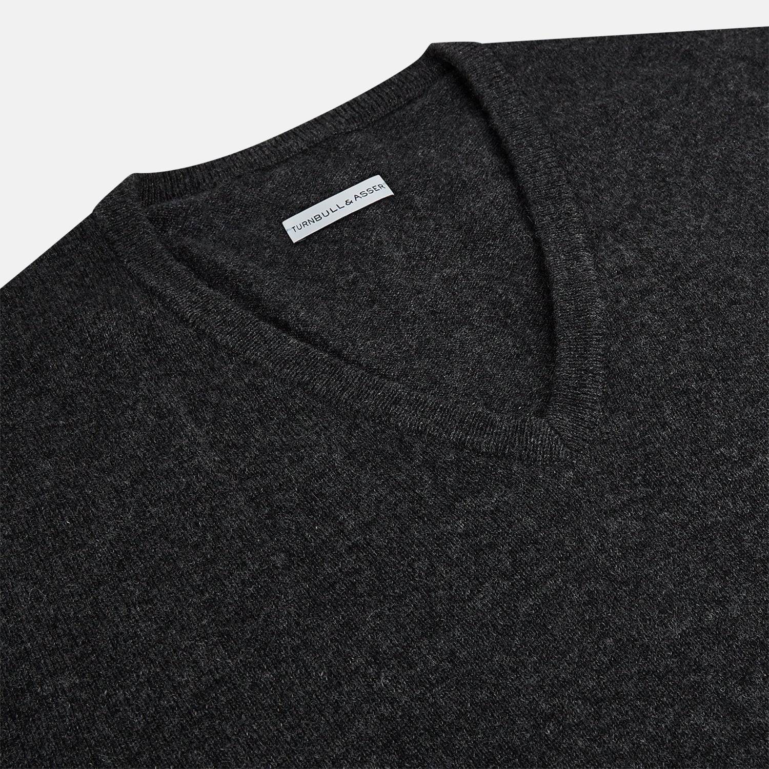 View 2 of product The Turnbull & Asser Charcoal Grey Melange V-Neck Cashmere Jumper is shown on a white background, featuring long sleeves, ribbed cuffs and hem for classic style and comfort.