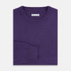 View 4 of product The Turnbull & Asser Purple Cashmere Round Neck Jumper features long sleeves, ribbed cuffs, hem, and collar for an elegant silhouette. This versatile knitwear piece is shown against a white background.