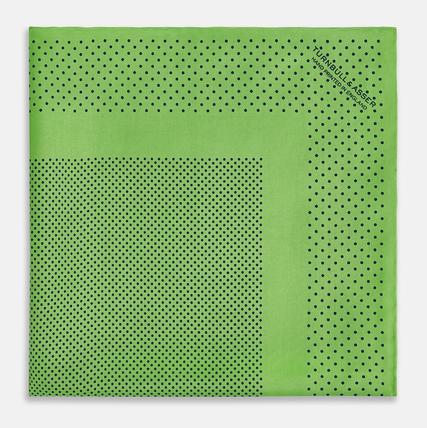 View 1 of product The Fern Green Dot Silk Pocket Square by Turnbull & Asser is crafted from pure silk, featuring a subtle black polka dot border with a denser dot pattern at the center and the brand name printed in the upper right corner.