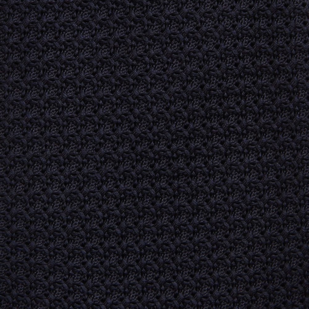 The GRENADINE NEW NAVY TIE by Turnbull & Asser features a dark navy blue woven texture, making it the perfect accessory for refined looks. Displayed against a plain white background.