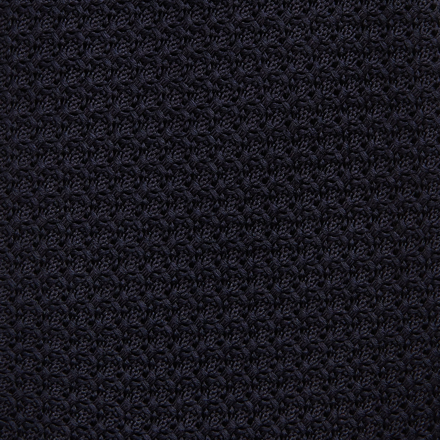 View 3 of product The GRENADINE NEW NAVY TIE by Turnbull & Asser features a dark navy blue woven texture, making it the perfect accessory for refined looks. Displayed against a plain white background.