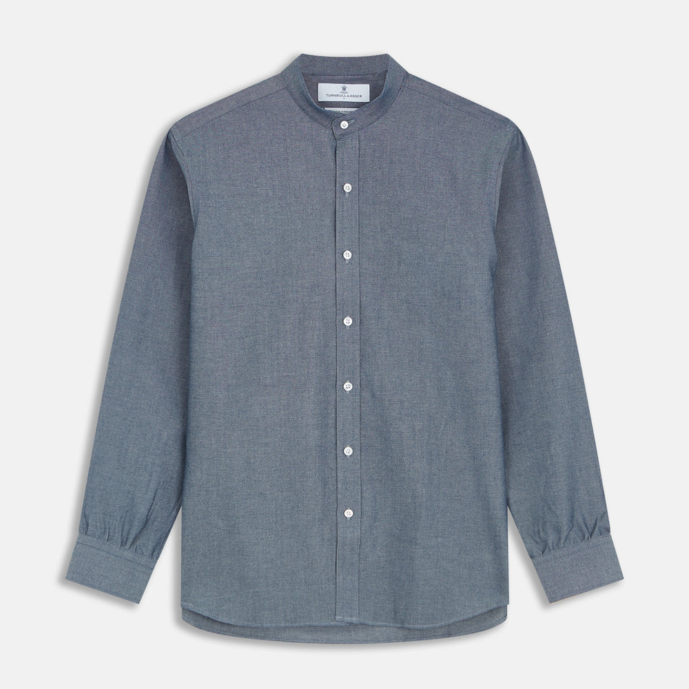 The Turnbull & Asser Plain Blue Oxford Cotton Weekend Fit Blake Shirt features long sleeves, a stand collar, and white buttons, displayed flat on a white background.