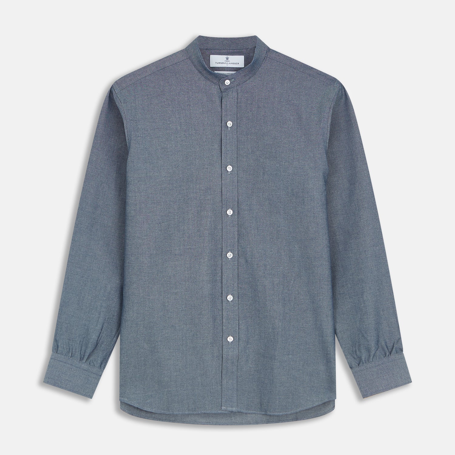 View 1 of product The Turnbull & Asser Plain Blue Oxford Cotton Weekend Fit Blake Shirt features long sleeves, a stand collar, and white buttons, displayed flat on a white background.