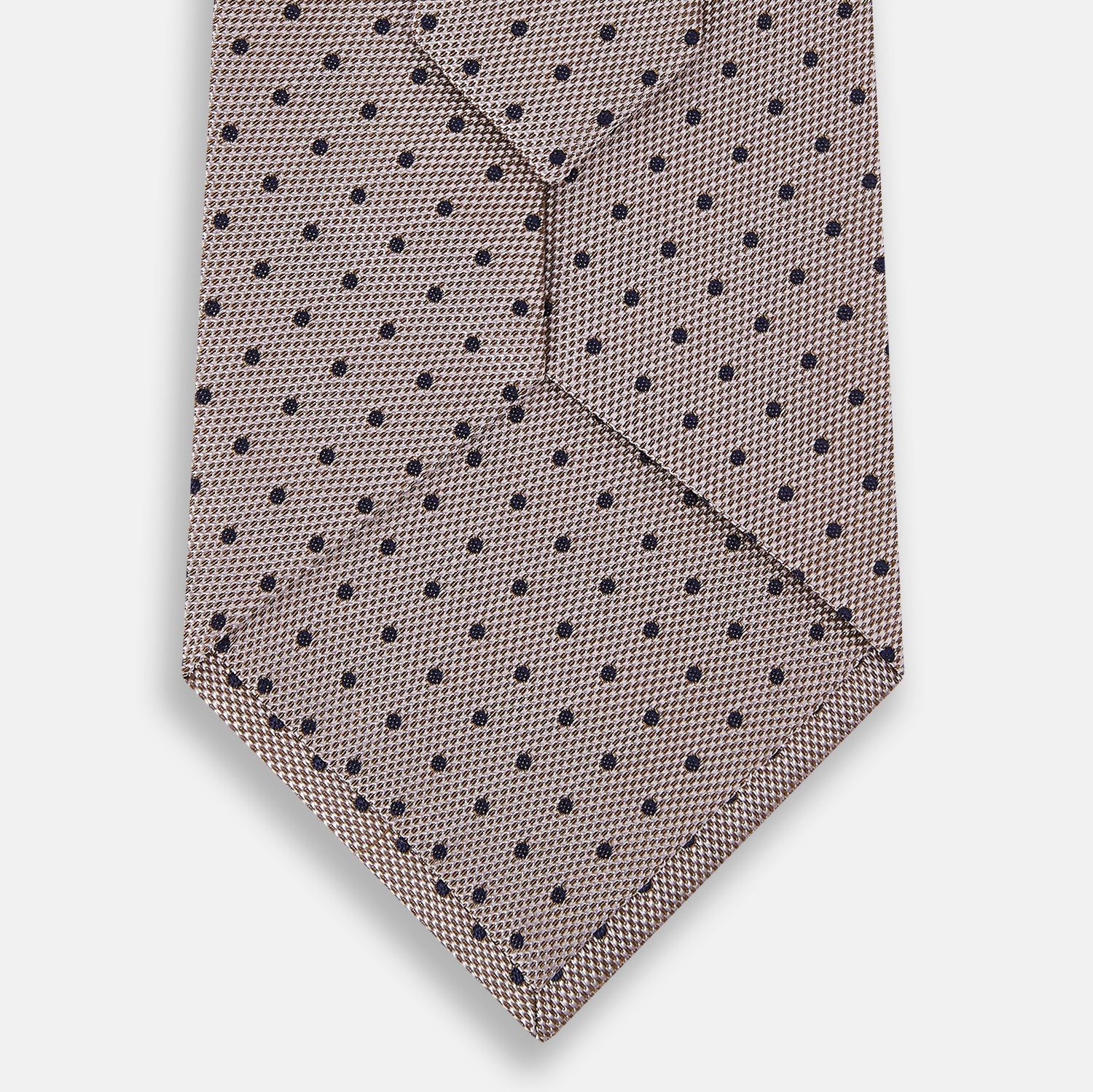 View 3 of product The Turnbull & Asser Navy and Lilac Micro Dot Silk Tie, featuring subtle micro dots, is the perfect refined accessory for smart outfits, shown rolled up against a plain white background.
