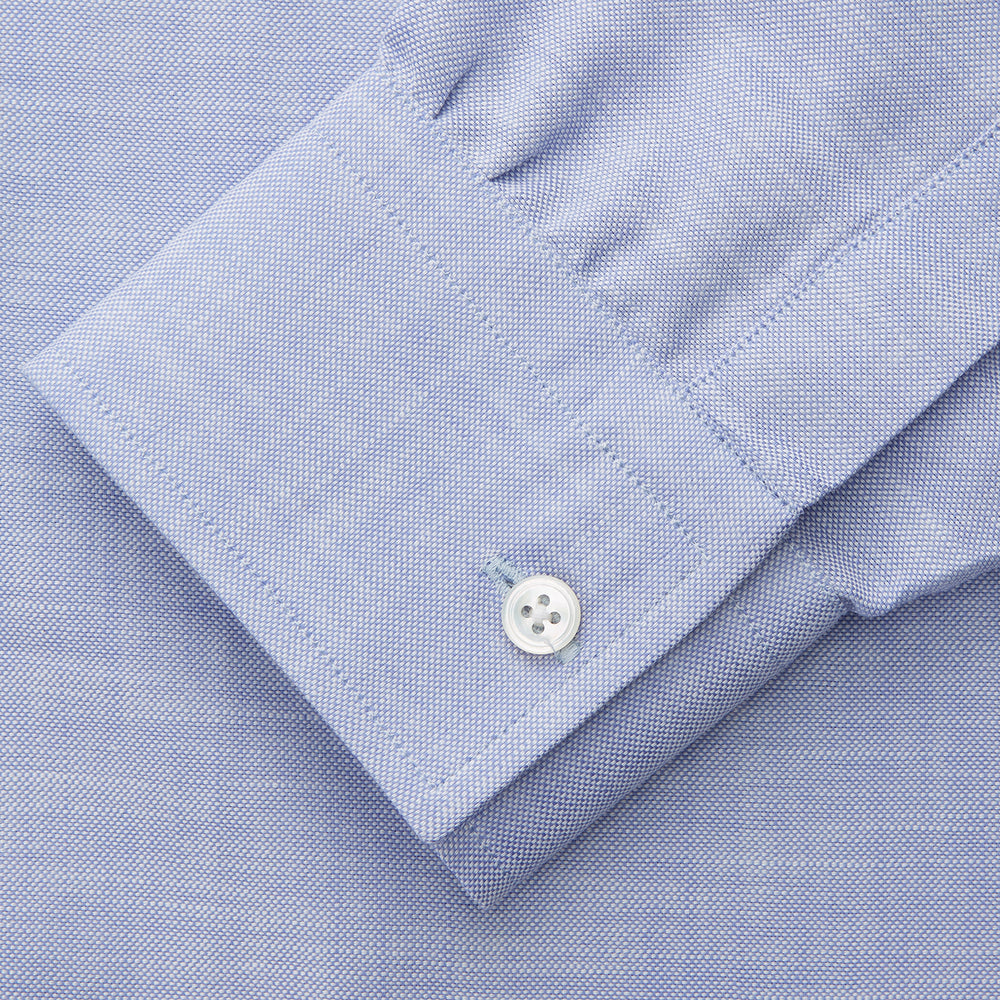 The Turnbull & Asser Pale Blue Weekend Fit Hayne Shirt features a Dorset collar, white buttons, and 1-button cuffs. This casual, long-sleeve button-down is displayed laid flat on a white background.