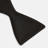 View 5 of product The Casino Royale Shantung Silk Bow Tie by Turnbull & Asser, as seen on James Bond, features a classic shape in black silk and is set against a plain white background—a timeless gentleman’s accessory.