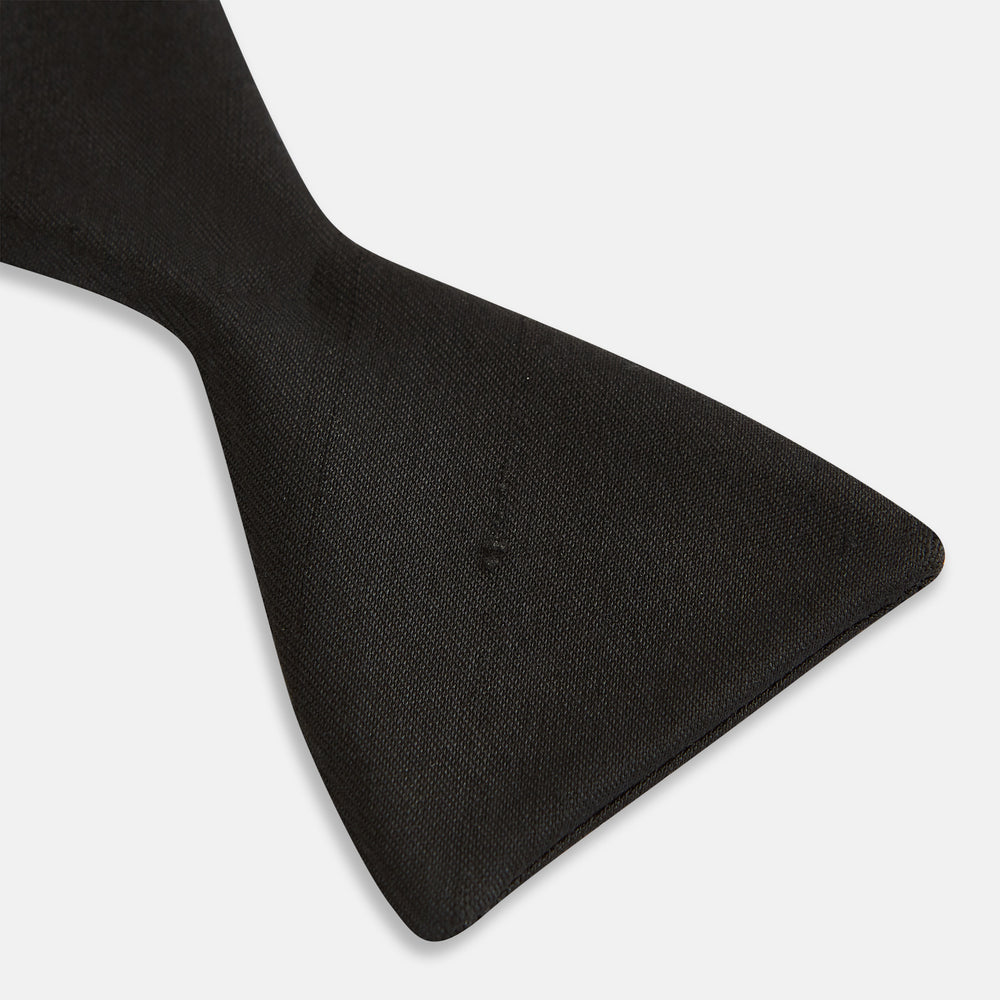 The Casino Royale Shantung Silk Bow Tie by Turnbull & Asser, as seen on James Bond, features a classic shape in black silk and is set against a plain white background—a timeless gentleman’s accessory.