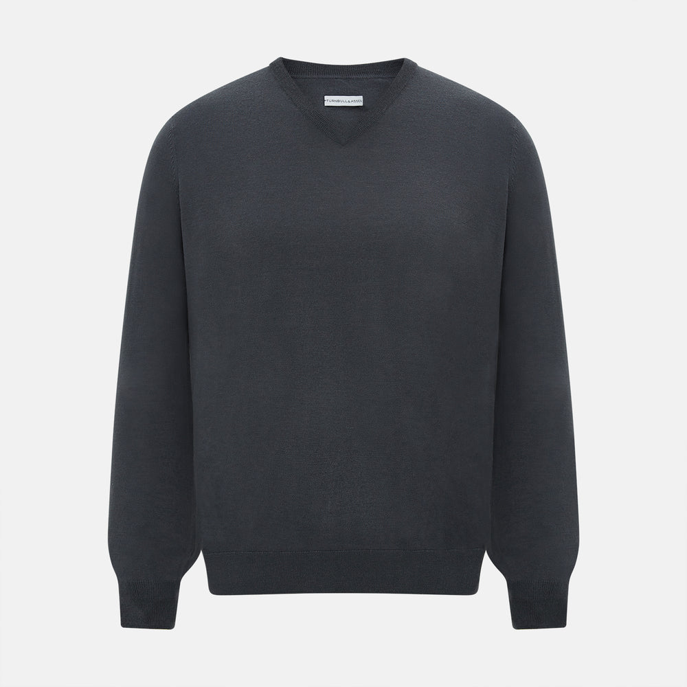 The Turnbull & Asser Charcoal Grey Merino V-Neck Jumper is shown against a white background, featuring long sleeves, a relaxed fit, and ribbed cuffs and hem for comfort.