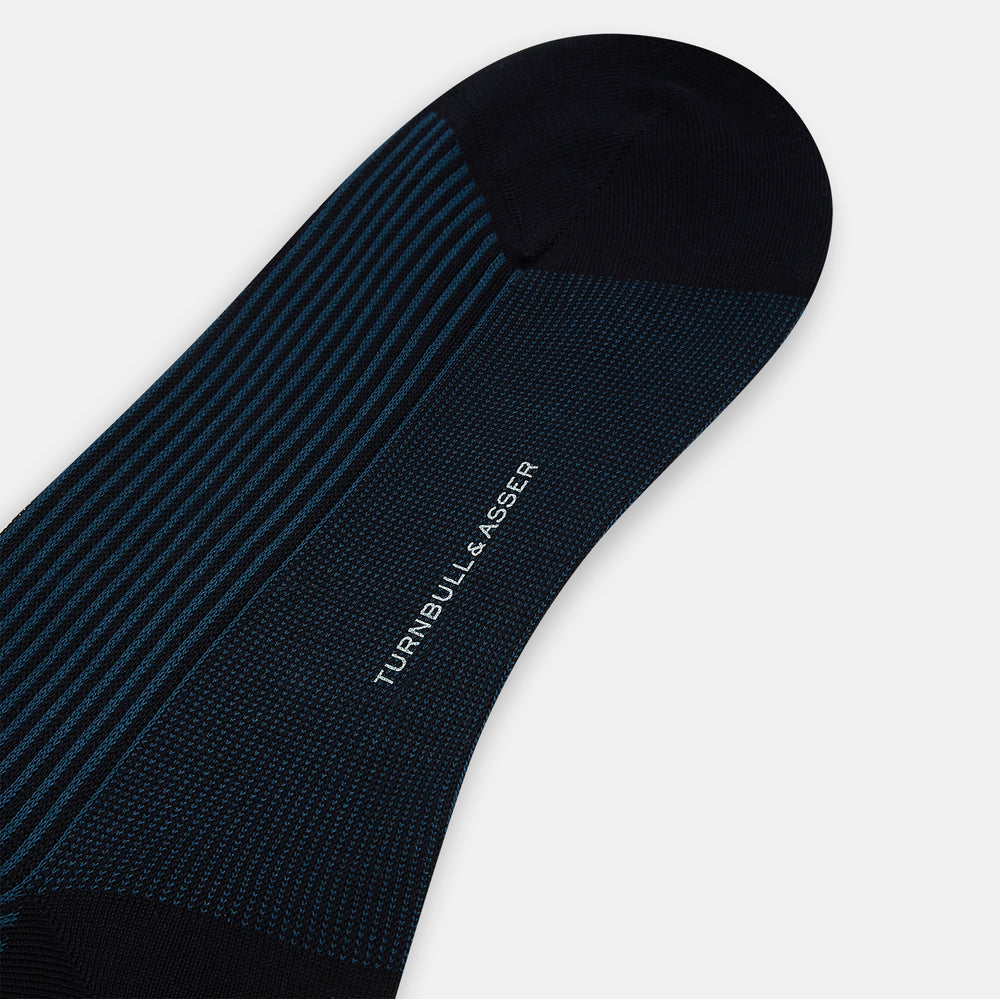 The Navy/Blue Thin Striped Long Socks by Turnbull & Asser feature an over the calf design with a dark upper and navy-black vertical stripes, made from soft mercerised Egyptian cotton for comfort. Displayed on a white background.