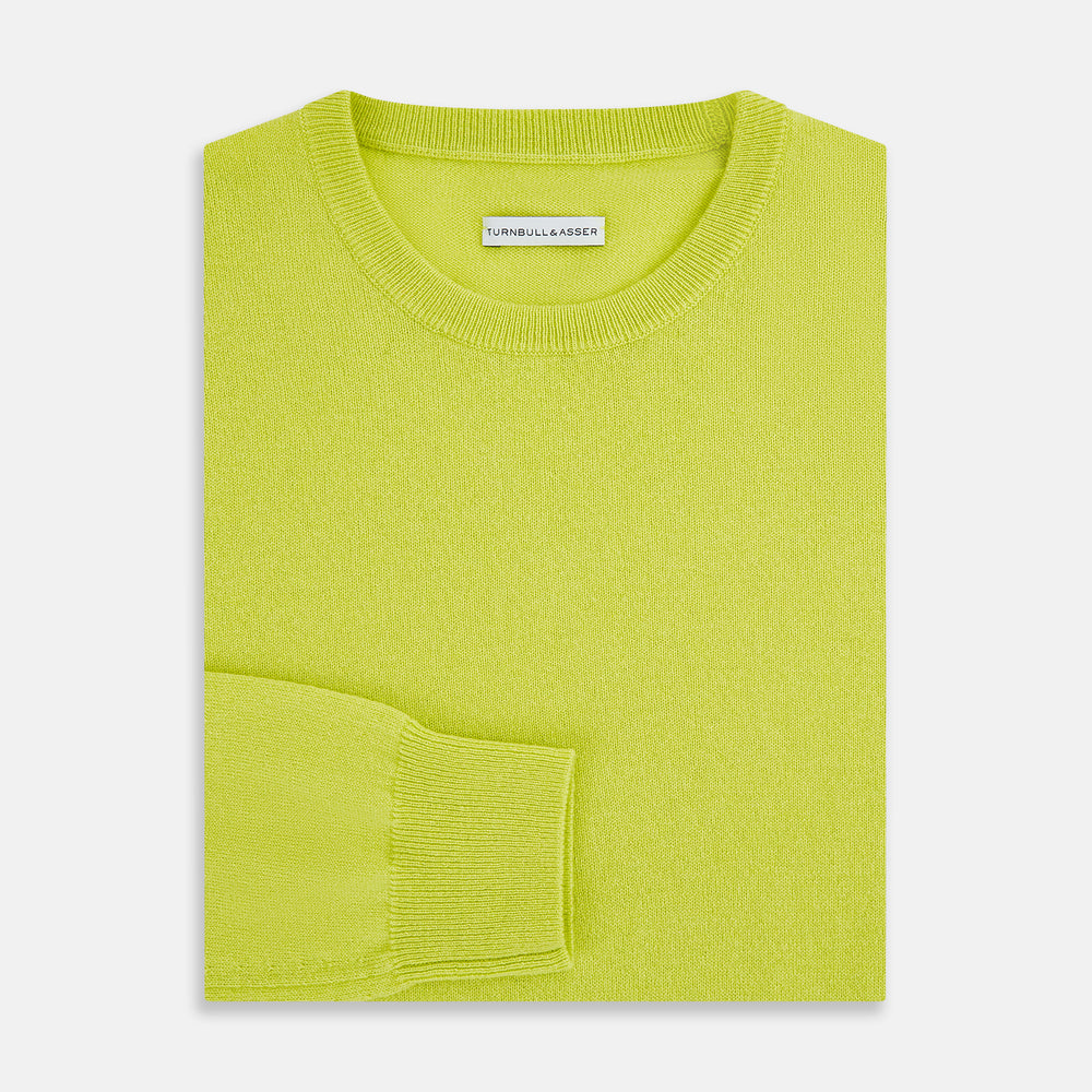 The Turnbull & Asser Lemon Green Cashmere Round Neck Jumper features long sleeves with ribbed cuffs and hem, displayed on a white background.