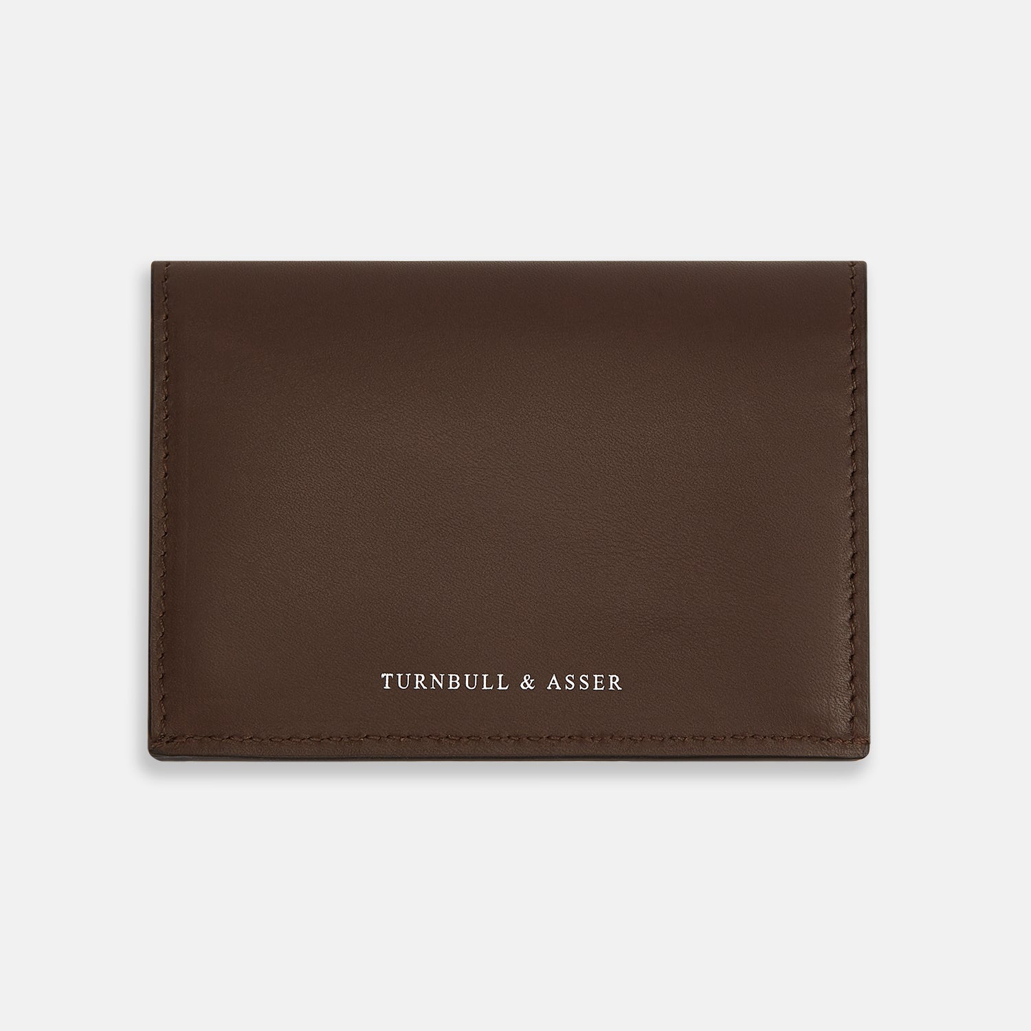 View 1 of product The Dark Brown Leather Bi-Fold Card Holder by Turnbull & Asser features neat edge stitching and the brand's name embossed in white on the front.