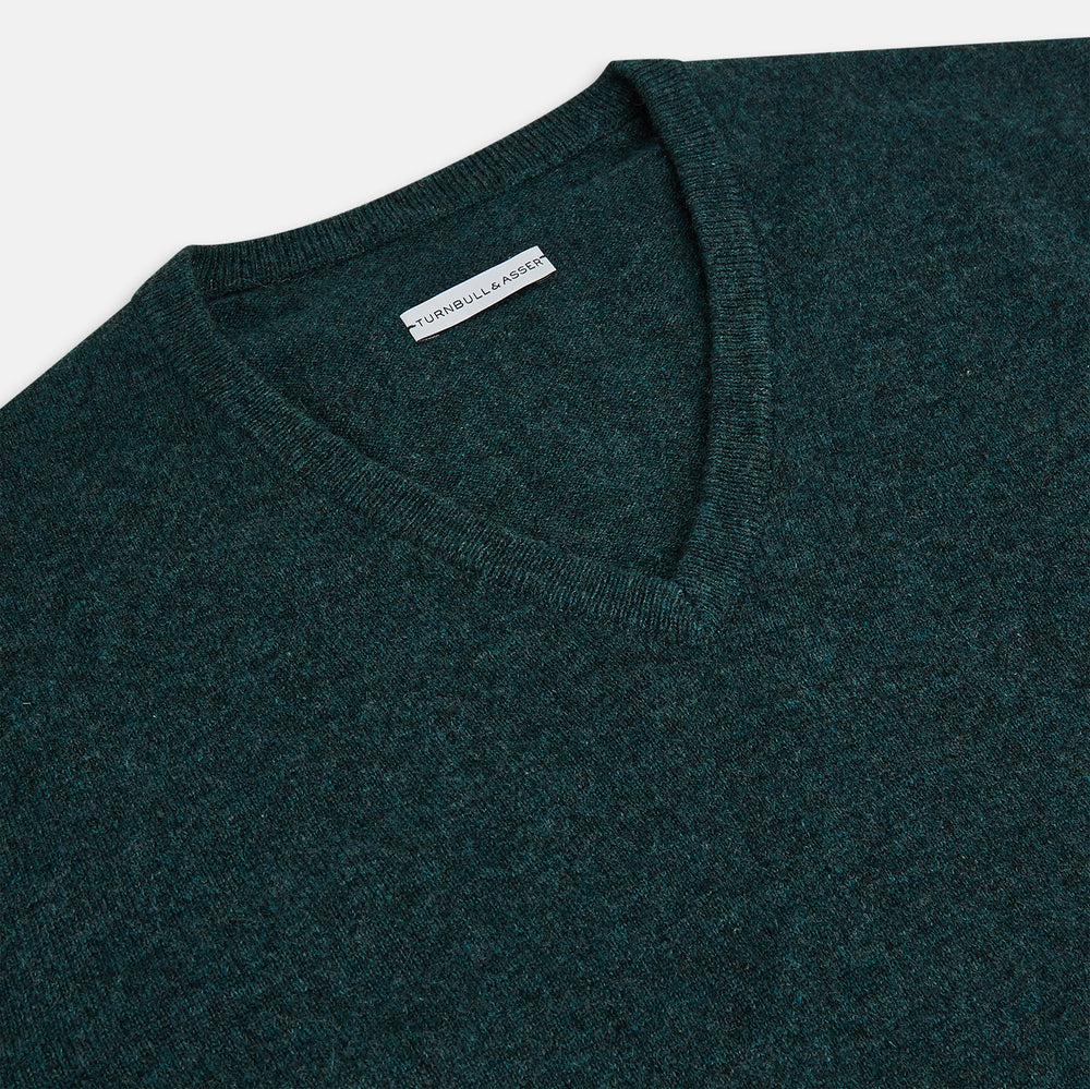 The Turnbull & Asser Forest Green Cashmere V-Neck Jumper features long sleeves, ribbed cuffs, collar, and hem. Shown against a white background, it's a classic knitwear piece ideal for layering.