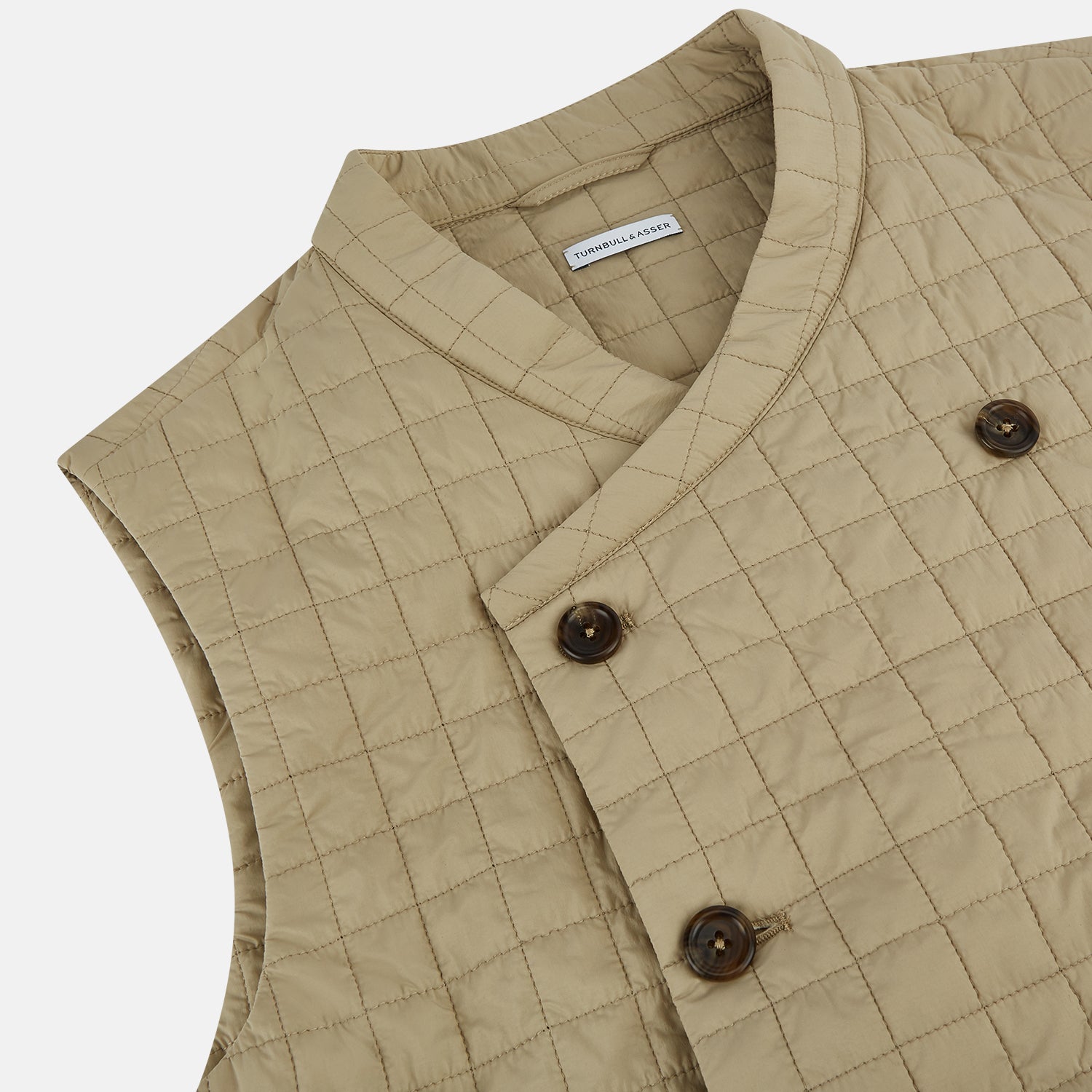 View 2 of product The Turnbull & Asser Sand Double-Breasted Quilted Gilet features a sleeveless design, brown buttons, slanted chest pocket, and two zippered side pockets—perfect for modern layered dressing. Shown on a plain white background.