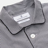 View 5 of product The Turnbull & Asser Black Candy Stripe Cotton Hyde Pyjama Set for men features soft cotton striped pajamas with a long-sleeve, button-up shirt detailed with black piping and three pockets, plus matching pants, both laid flat on a white background.