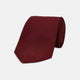 The Turnbull & Asser Plain Woven Grenadine Silk Tie, shown rolled at one end on a white background, features a rich burgundy hue and textured pattern—an essential accessory for sophisticated looks.