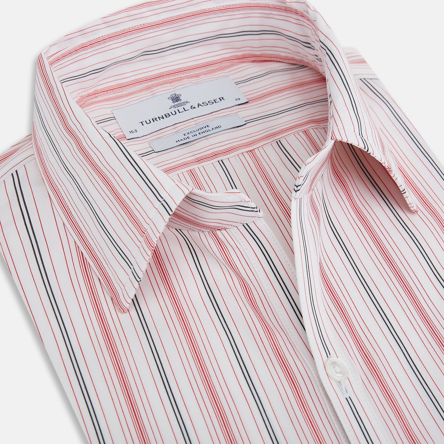 View 2 of product The Red Multi Pencil Stripe Windsor Shirt by Turnbull & Asser features long sleeves, buttoned cuffs, a Turnbull collar, and classic British tailoring with vertical red, pink, and white stripes.