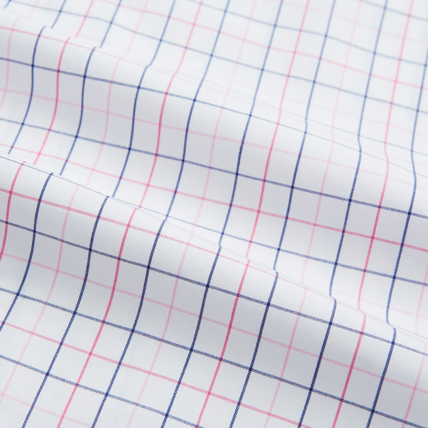 View 6 of product The Turnbull & Asser Pink Overlay Grid Check Mayfair Shirt is a long-sleeved, button-up with a collar and buttoned cuffs, featuring a white base and thin pink grid lines. Laid flat against a white surface.