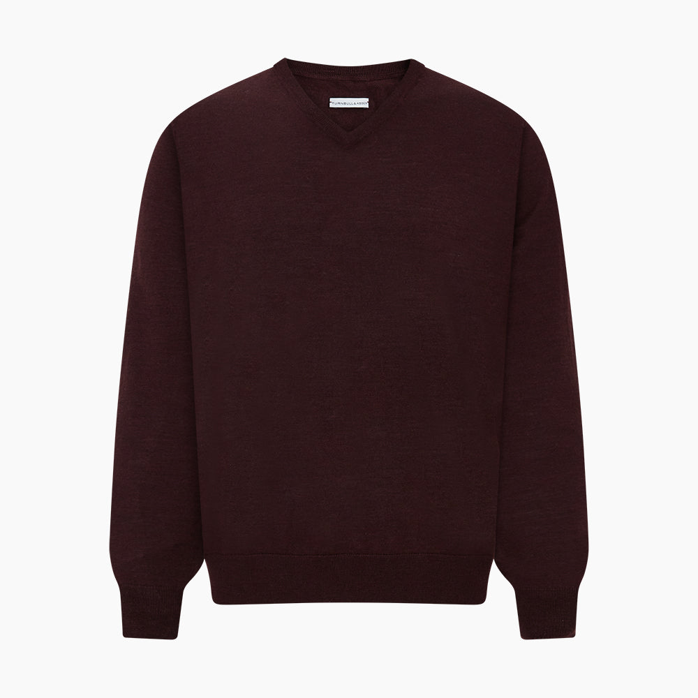 The Turnbull & Asser Burgundy Fine Merino V-Neck Jumper features a classic plain knit design with long sleeves, showcased against a crisp white background.