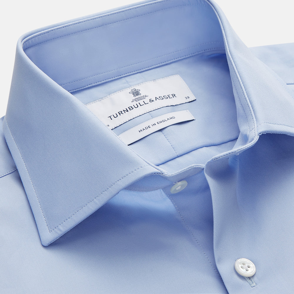 Turnbull & Asser's Tailored Fit Blue Cotton Shirt features a Kent collar, 3-button cuffs, and a clean design—ideal with a navy suit. Displayed on a plain white background.