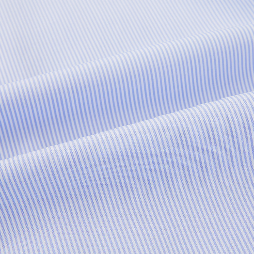 The Turnbull & Asser Pale Blue Hairline Stripe Pyjama Shirt features long sleeves and a single chest pocket, offering an elegant sleepwear style—shown on a plain white background.