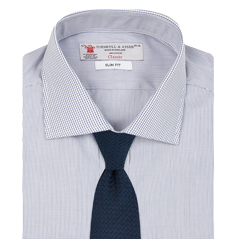 The Turnbull & Asser Slim Fit Blue Checked Shirt features long sleeves, contrasting white buttons, a regent collar, and distinct blue check pattern detailing on the cuff.