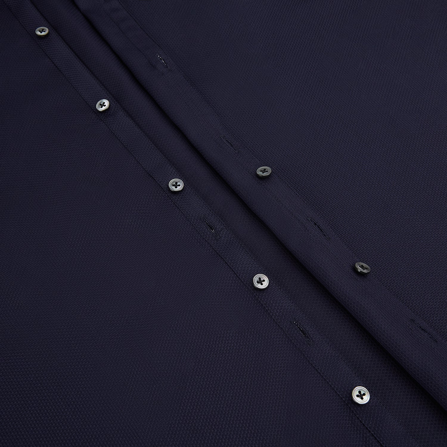 View 7 of product The Navy Textured Windsor Shirt by Turnbull & Asser features long sleeves, a Windsor collar, buttoned cuffs, and white buttons—a fine example of British craftsmanship—set against a plain white background.