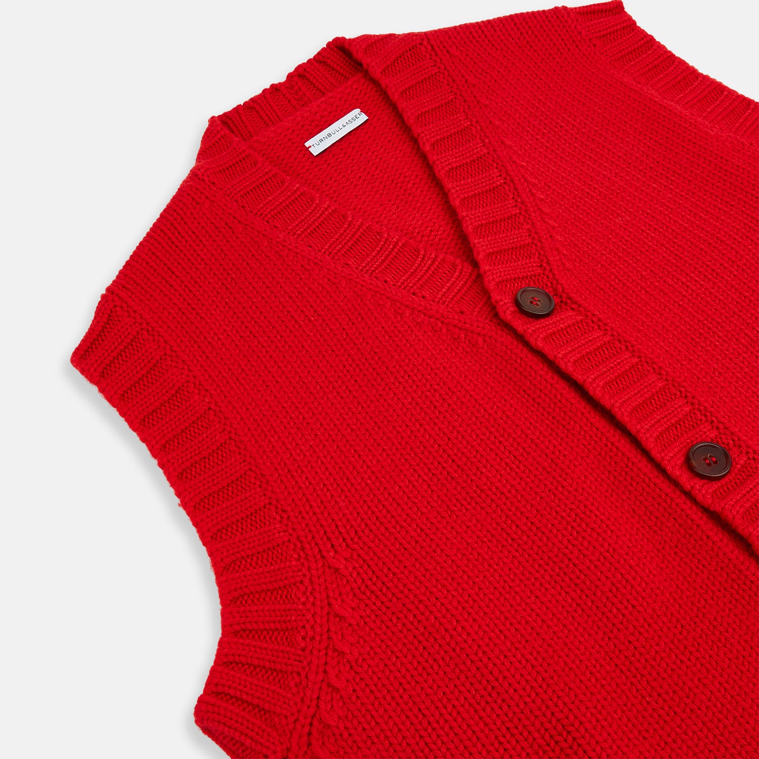 View 2 of product The Turnbull & Asser Red Merino V-Neck Sleeveless Cardigan features a ribbed collar, button front, and two front pockets—a refined lightweight layer—shown against a plain white background.