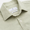 View 2 of product The Turnbull & Asser Soft Green Cashmerello Weekend Fit Finch Shirt features a Derby collar, long sleeves, chest pocket, white buttons, and cuffs. Laid flat on a white background.