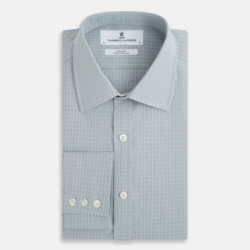Turnbull & Asser Pale Blue Fine Check Mayfair Shirt—a long-sleeve button-up with classic collar, buttoned cuffs, white buttons, and a subtle check pattern in sanforised cotton—displayed on a white background.