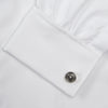 View 6 of product A neatly folded Turnbull & Asser White Oxford Shirt with T&A collar and double cuffs is displayed on a light blue background.