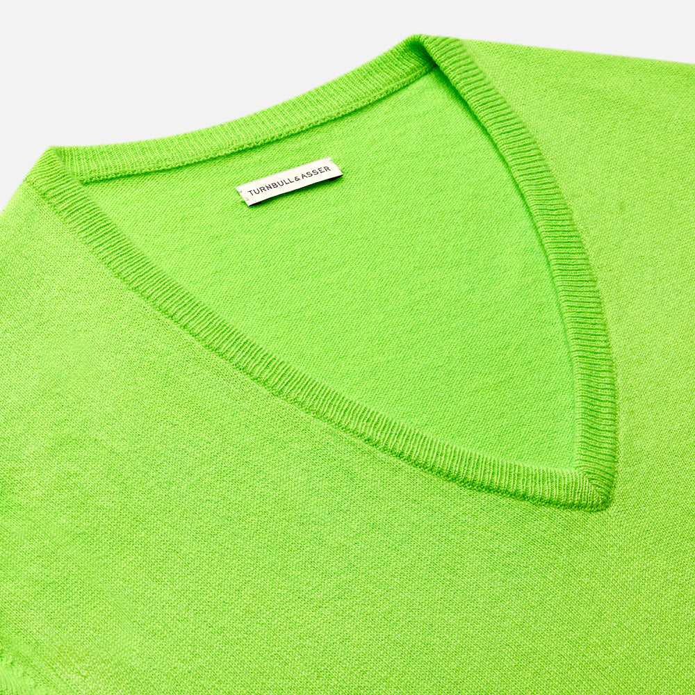 The Turnbull & Asser Bright Green Cashmere V-Neck Jumper, a long-sleeved knitwear piece, is showcased against a plain light gray background.