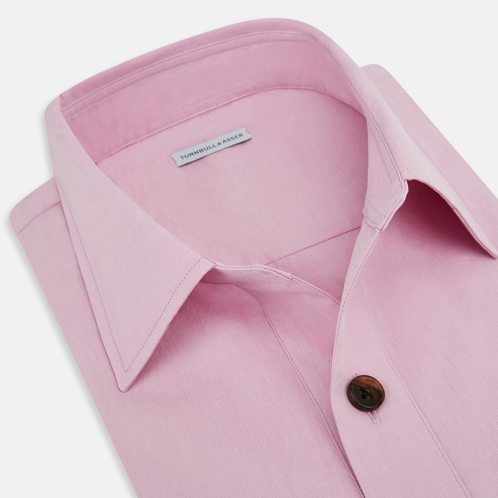 The Pink Hyde Overshirt by Turnbull & Asser is a long-sleeved, light pink sanforised cotton shirt with a left chest pocket and dark buttons—an elegant, laid-back alternative to a blazer.