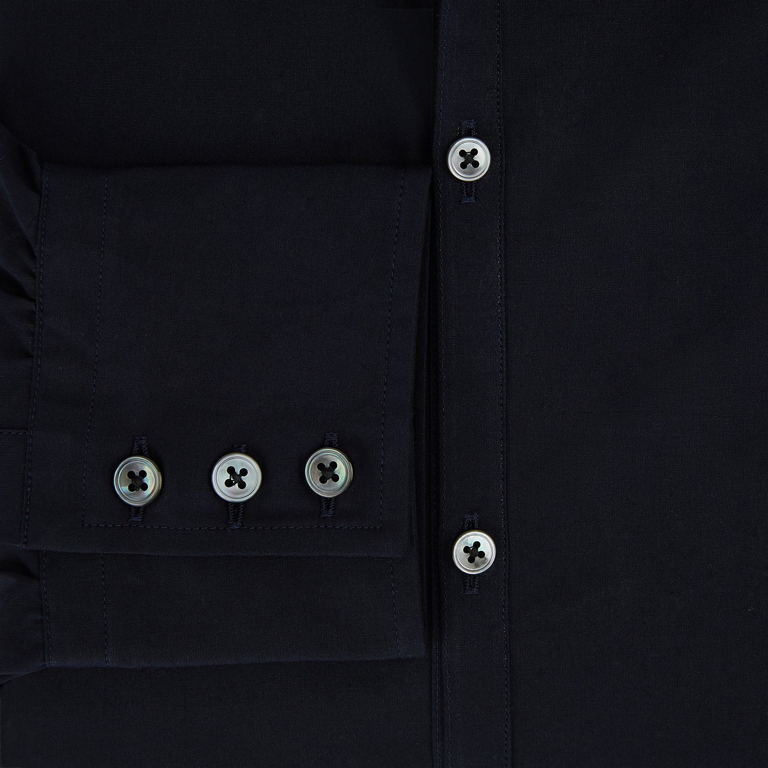 View 4 of product The NAVY BLUE WINDSOR SHIRT by Turnbull & Asser features long sleeves, a classic Windsor collar, white buttons, and buttoned cuffs—highlighting refined British craftsmanship against a plain white background.