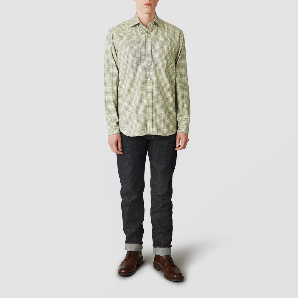 A person faces forward wearing the Turnbull & Asser Green Check Weekend Fit Shirt with Derby Collar and 1-Button Cuffs, dark cuffed jeans, and brown leather shoes against a plain light gray background.