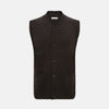 View 1 of product The Brown Merino V-Neck Sleeveless Cardigan by Turnbull & Asser features ribbed edges, front pockets, and a button-up front—ideal as an elegant light layer. Shown against a plain white background.