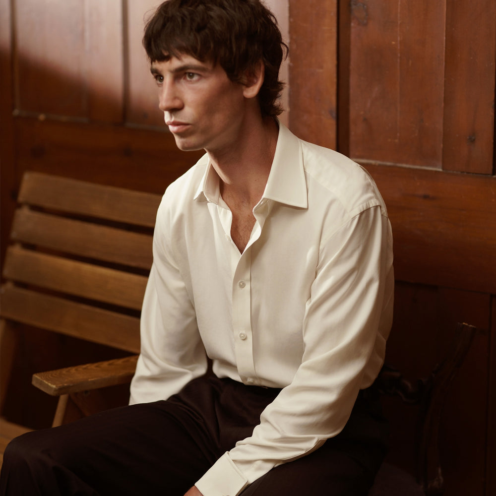 The Cream Silk Shirt by Turnbull & Asser features a T&A collar and 3-button cuffs, displayed folded on a light background—perfect for sophisticated evening wear.