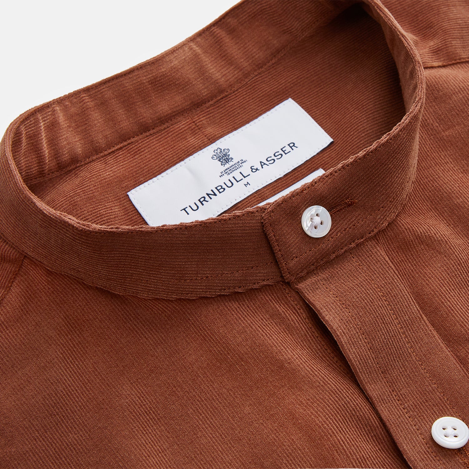 View 4 of product The Turnbull & Asser Rust Cotton Weekend Fit Blake Shirt features long sleeves, a stand collar, and white buttons—an ideal casual piece displayed flat on a white background.