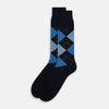 View 2 of product The Turnbull & Asser Navy Check Mid-Length Sock, crafted from ultra-soft cotton, features a blue and light blue argyle pattern with diamond shapes and dotted lines, and is showcased against a plain white background.