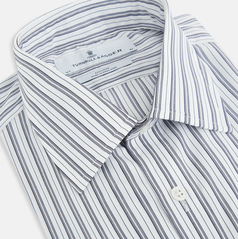 The Turnbull & Asser Navy Multi Stripe Mayfair Shirt, a pure cotton button-up with long sleeves and a collar, features thin vertical blue and white stripes and is displayed flat on a white background.