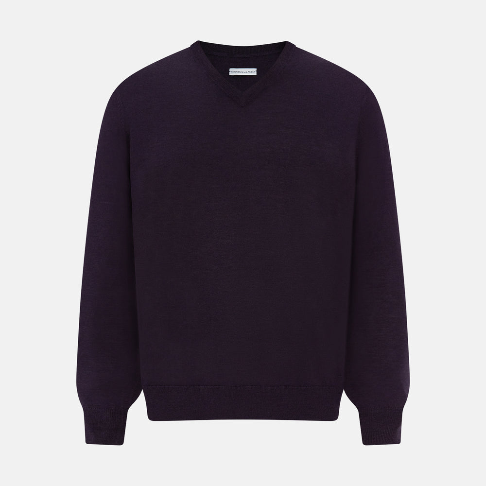 The Turnbull & Asser Dark Purple Fine Merino V-Neck Jumper features long sleeves and a classic knit, shown against a white background.